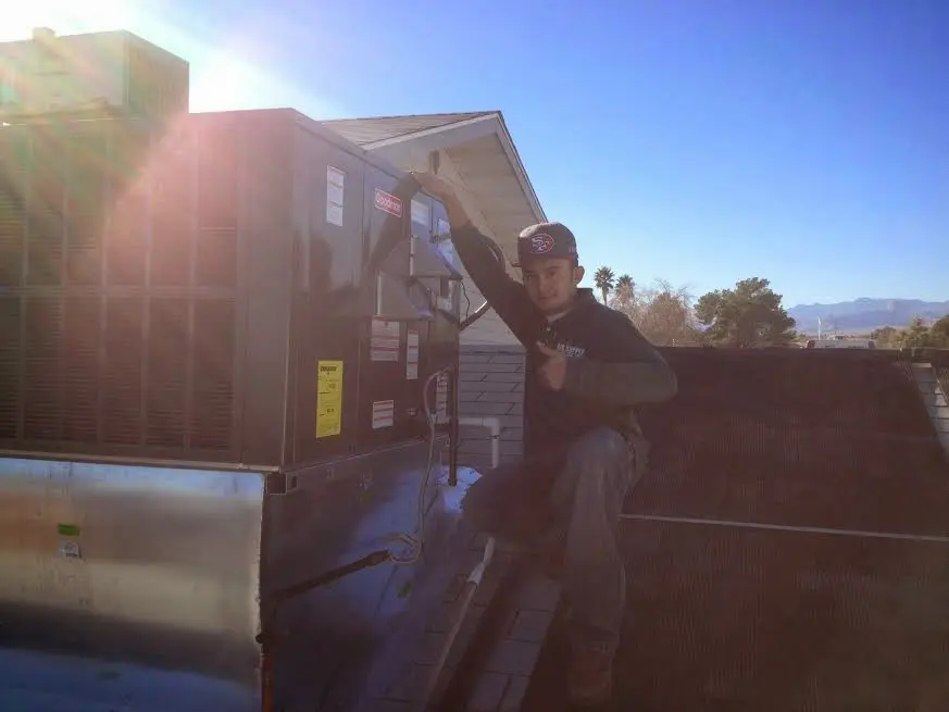 HVAC technician performing HVAC Inspection on a rooftop unit in Mundelein