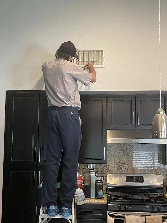 Technician inspecting an air vent during HVAC service in Mundelein